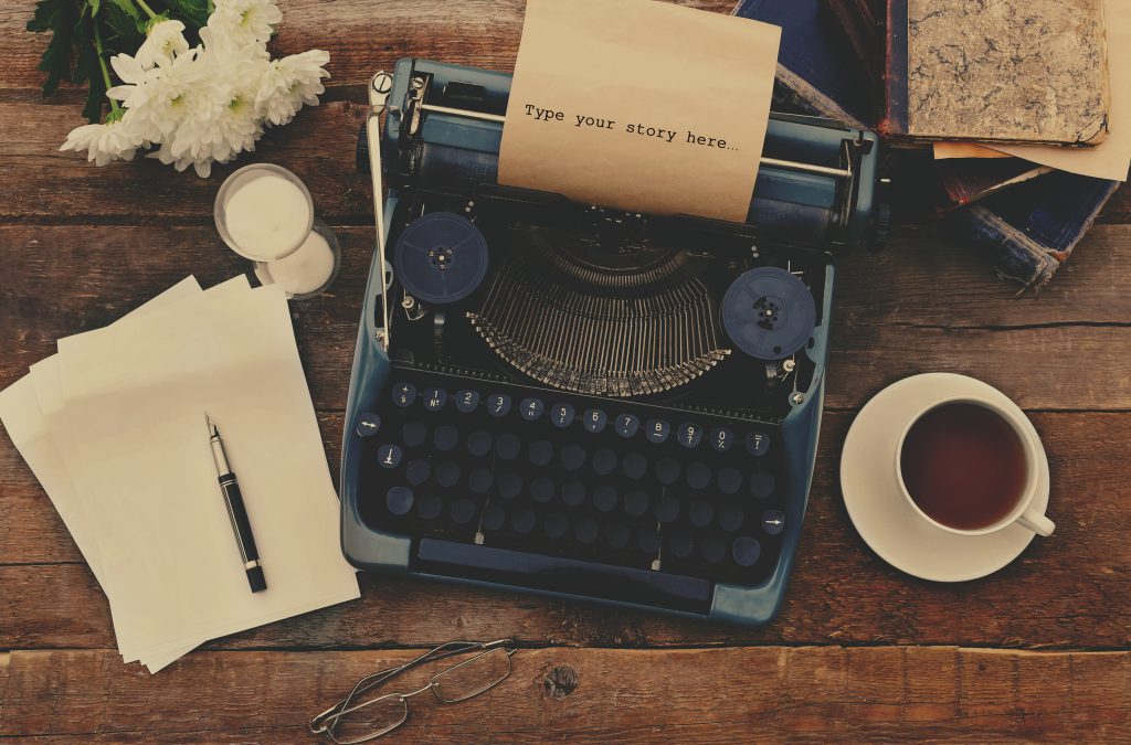 Vintage black typewriter on decorated wooden table, outdoors, close up